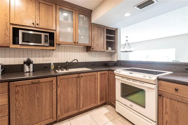 a kitchen with granite countertop cabinets stainless steel appliances and wooden cabinets