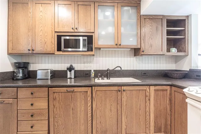 a kitchen with stainless steel appliances granite countertop a sink a stove and cabinets