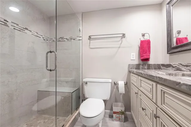 a bathroom with a granite countertop sink toilet and shower