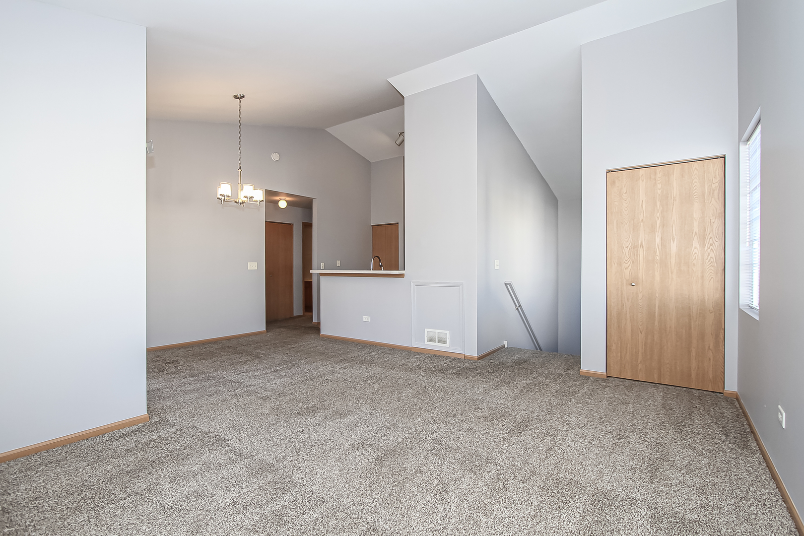 1640 McClure Road, Unit 1640 Aurora, IL 60505 - Photo 4 of 25 an empty room with chandelier fan and windows