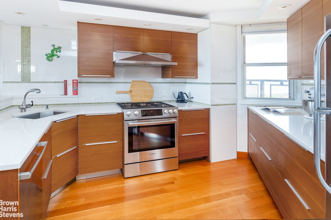 5700 Arlington Avenue, Unit 21R Bronx, NY 10471 - Photo 6 of 23 a kitchen with a stove a sink and a microwave
