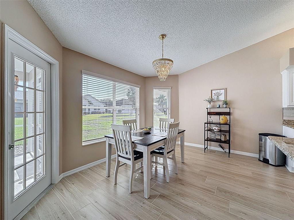 9428 Apple Dumpling Court Weeki Wachee, FL 34613 - Photo 13 of 40 a view of a dining room with furniture window and wooden floor