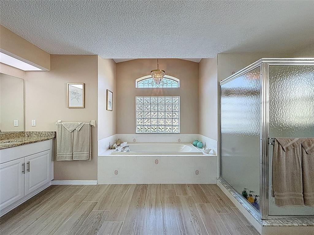 9428 Apple Dumpling Court Weeki Wachee, FL 34613 - Photo 18 of 40 a bathroom with a tub a sink and a window