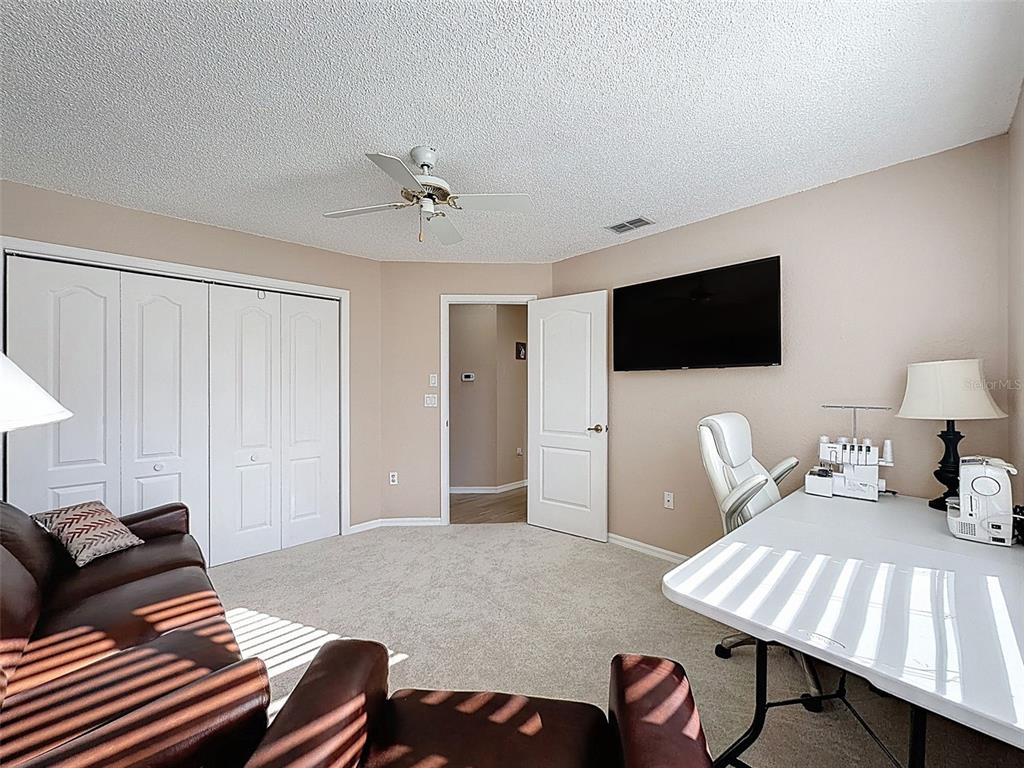 9428 Apple Dumpling Court Weeki Wachee, FL 34613 - Photo 23 of 40 a living room with furniture a flat screen tv and kitchen view