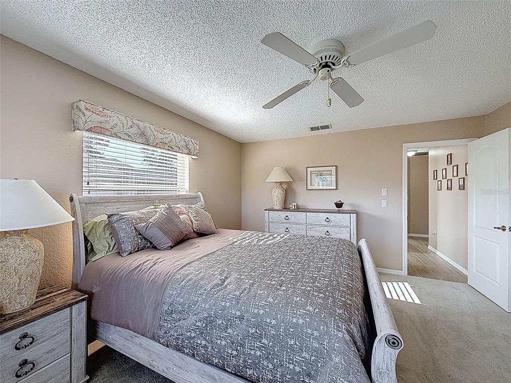 9428 Apple Dumpling Court Weeki Wachee, FL 34613 - Photo 27 of 40 a bedroom with a large bed and a chandelier