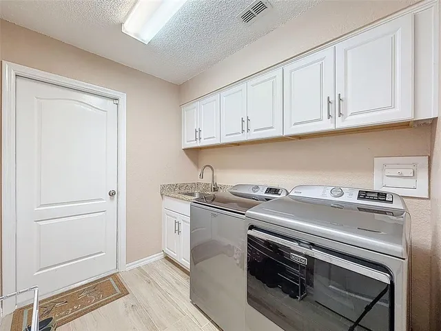 a kitchen with granite countertop white cabinets and stainless steel appliances