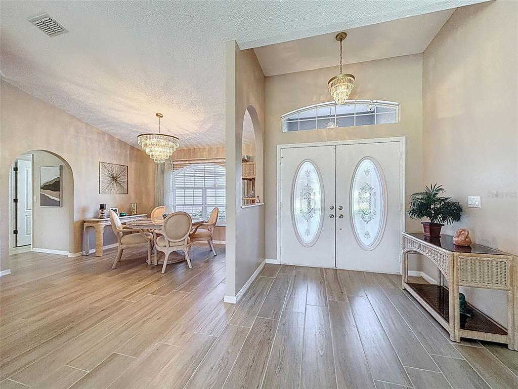9428 Apple Dumpling Court Weeki Wachee, FL 34613 - Photo 6 of 40 a living room with furniture a chandelier and wooden floor