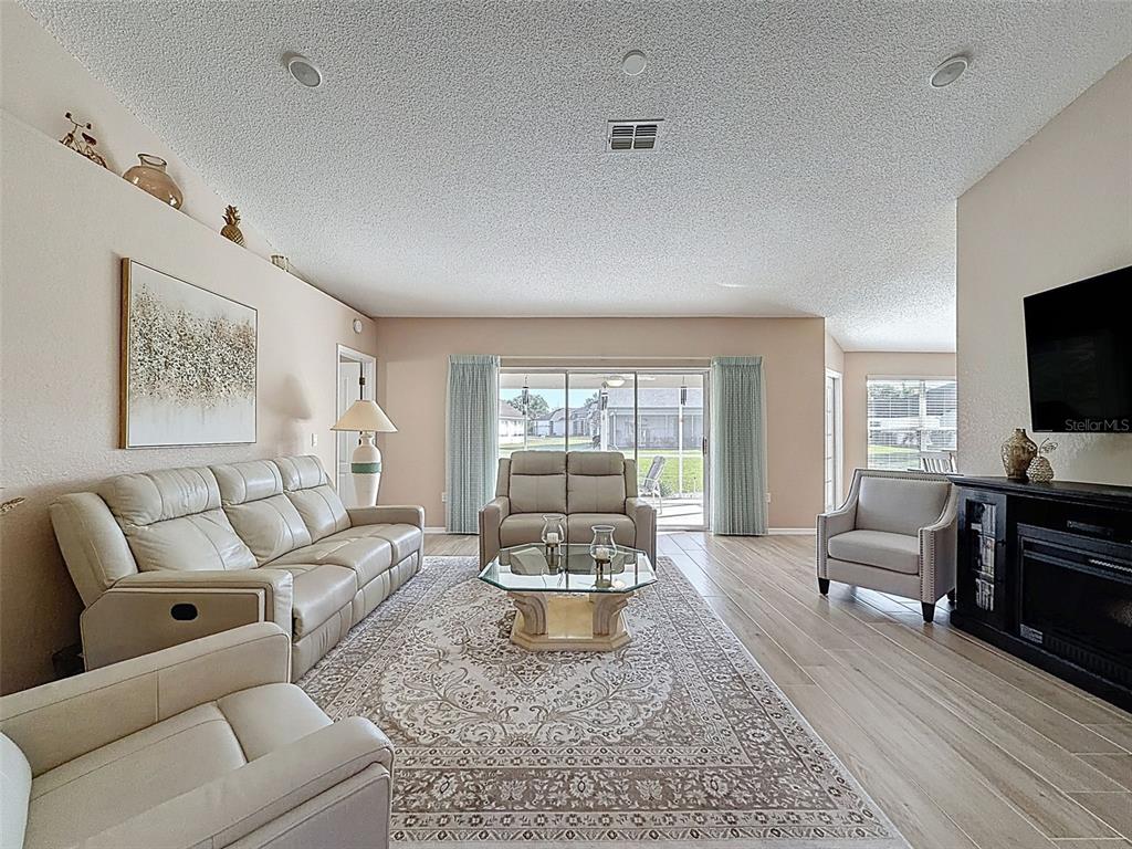 9428 Apple Dumpling Court Weeki Wachee, FL 34613 - Photo 7 of 40 a living room with furniture and a flat screen tv