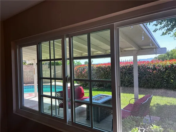 a view of a house with a floor to ceiling window and wooden fence