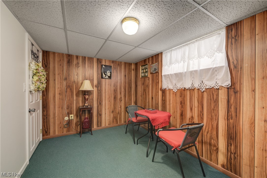 7094 Brandywine Road Parma Heights, OH 44130 - Photo 47 of 49 Sitting room featuring dark colored carpet, wooden walls, and a drop ceiling