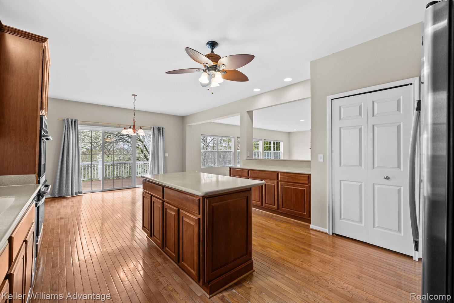 4100 Norwich Court Rochester, MI 48306 - Photo 16 of 72 Kitchen featuring light wood-style flooring, light countertops, freestanding refrigerator, ceiling fan, and a kitchen island