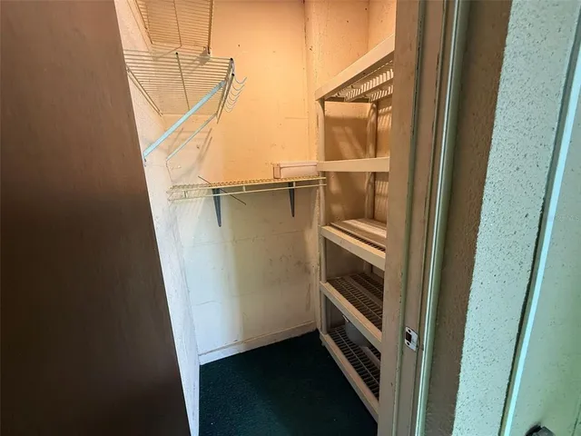 a view of an empty room with a kitchen