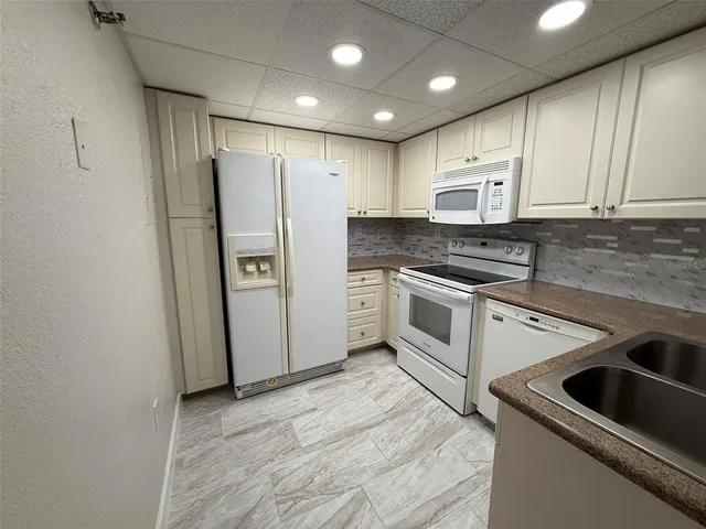 a kitchen with stainless steel appliances granite countertop a refrigerator a sink and a stove