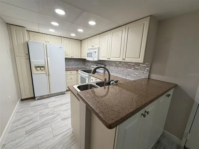 a kitchen with stainless steel appliances granite countertop a sink window and refrigerator