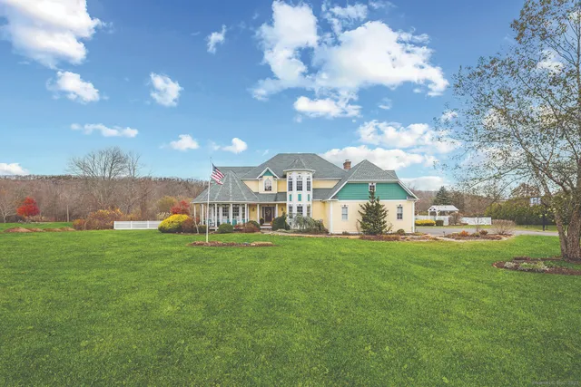 a view of a house with a yard and sitting area