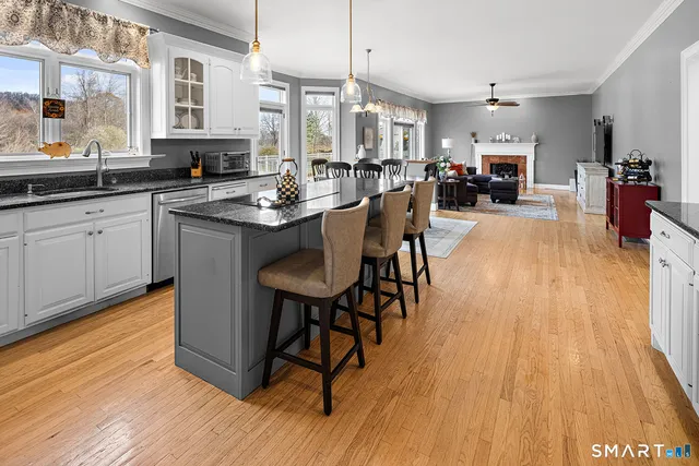 a kitchen with stainless steel appliances granite countertop a refrigerator a stove and a sink