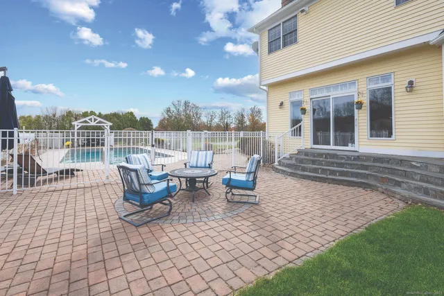 a view of a patio with table and chairs with wooden floor and fence