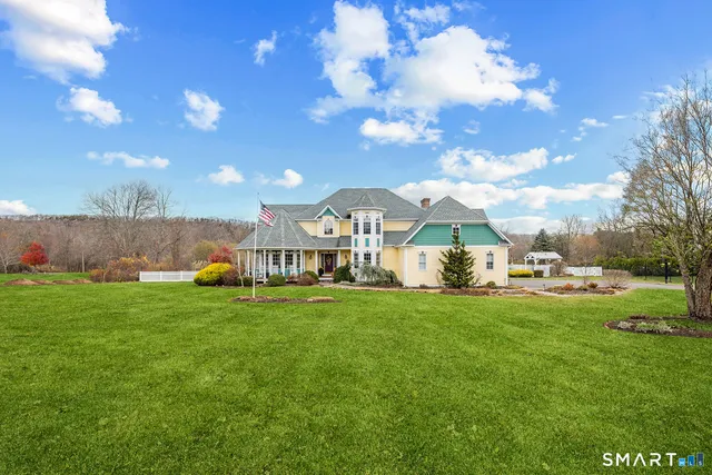 a view of a house with a yard and sitting area