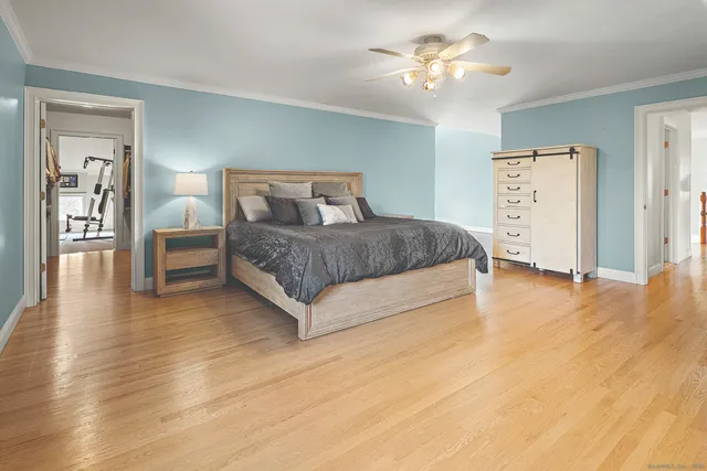 a spacious bedroom with a bed and a chandelier