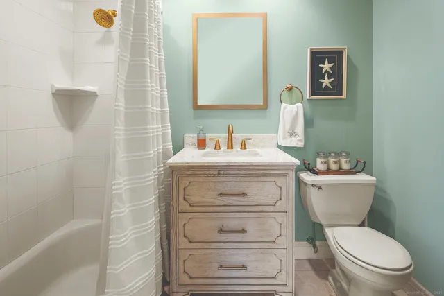 a bathroom with a sink mirror vanity and toilet