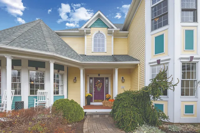 a view of a brick house with large windows and a yard
