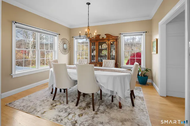 a dining room with furniture a chandelier and wooden floor