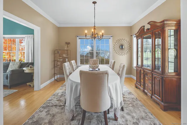 a dining room with furniture a chandelier and wooden floor