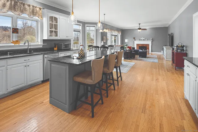 a kitchen with stainless steel appliances granite countertop wooden floors and table