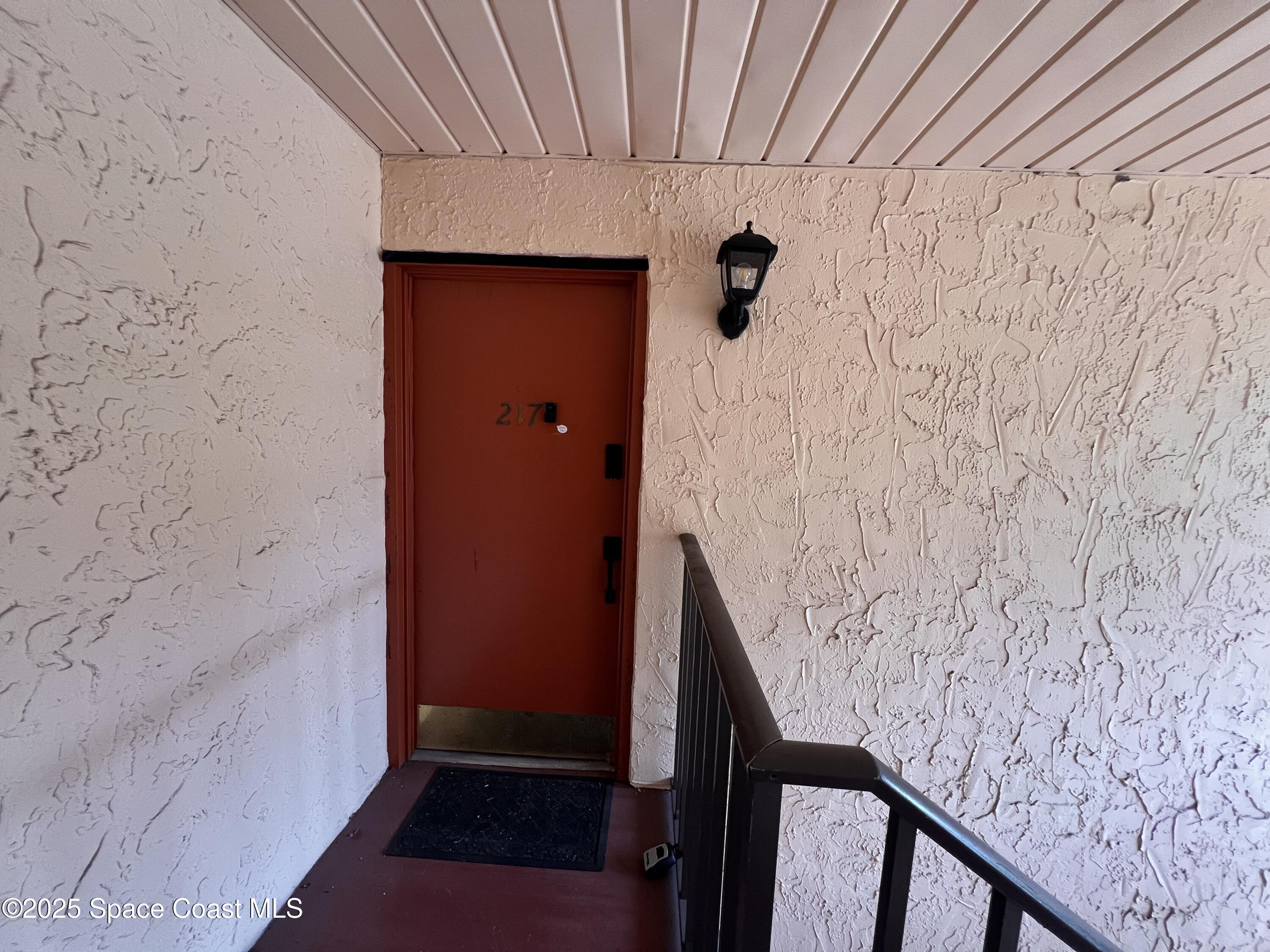 217 San Juan Circle Melbourne, FL 32935 - Photo 2 of 9 a view of wooden staircase with white walls