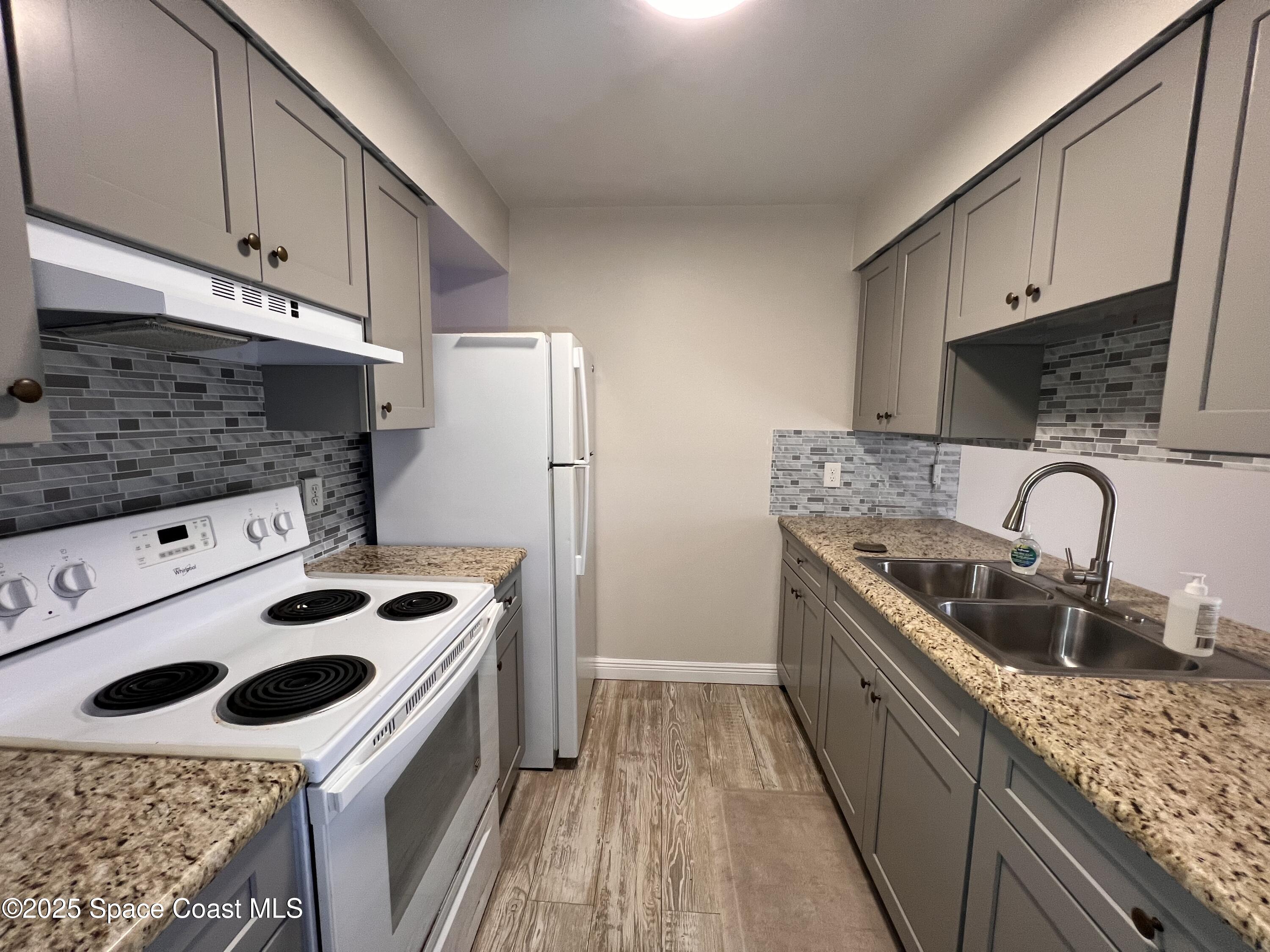 217 San Juan Circle Melbourne, FL 32935 - Photo 6 of 9 a kitchen with kitchen island stainless steel appliances a sink a stove and a refrigerator