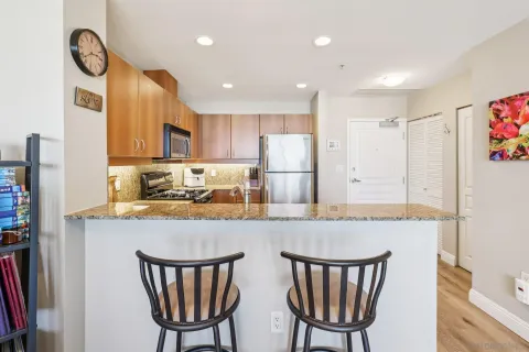 a kitchen with stainless steel appliances granite countertop a refrigerator and a stove top oven