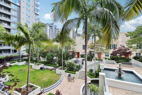 a kitchen with stainless steel appliances lots of white furniture a sink a stove a dining table and chairs