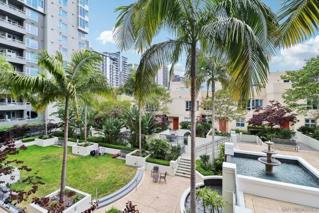 a kitchen with stainless steel appliances lots of white furniture a sink a stove a dining table and chairs