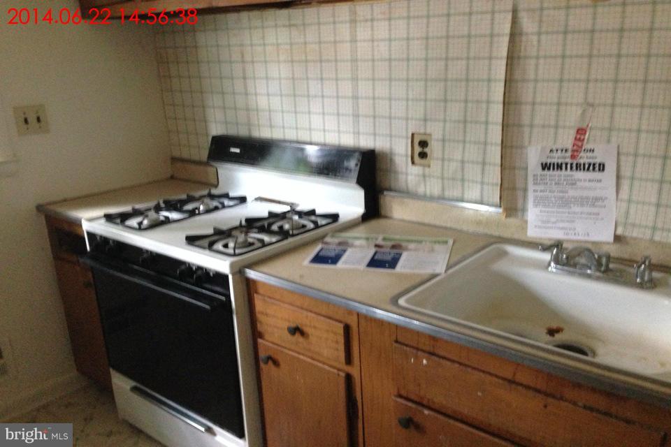 634 Queensgate Road Baltimore, MD 21229 - Photo 4 of 10 a white stove top oven sitting inside of a kitchen
