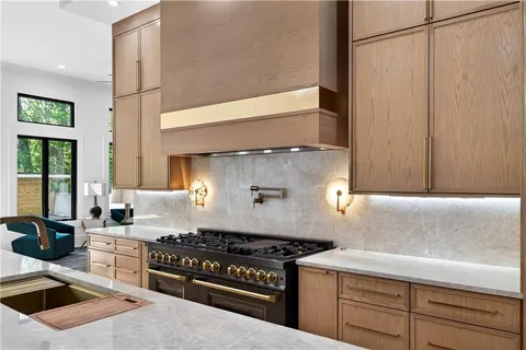 a kitchen with stainless steel appliances granite countertop a stove a sink and a refrigerator