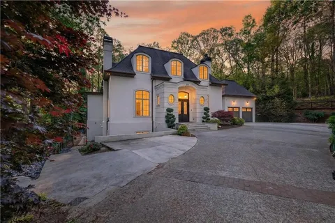 a front view of a house with a street and a tree