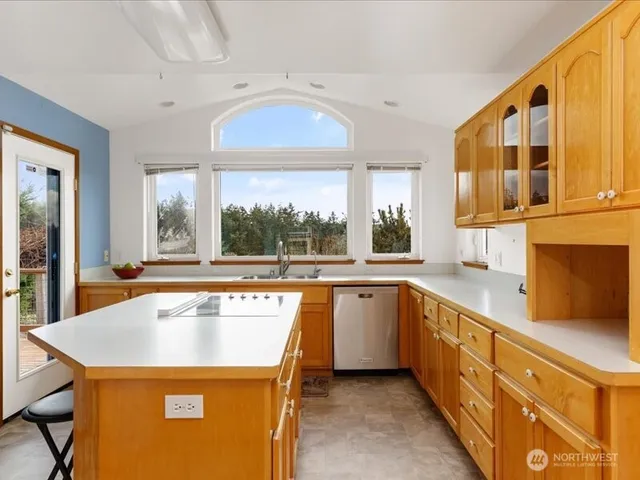 a view of a kitchen with a sink and wooden cabinets