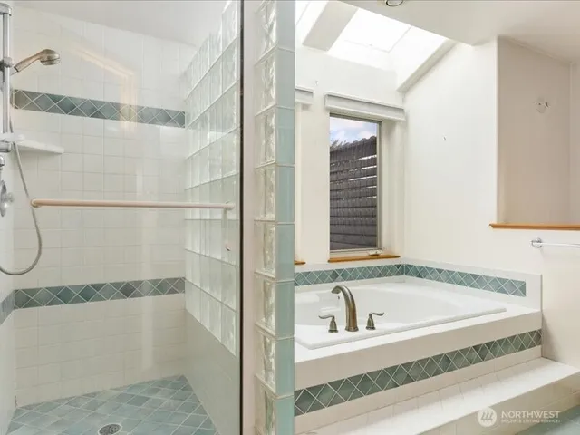 a bathroom with a granite countertop bathtub and a shower