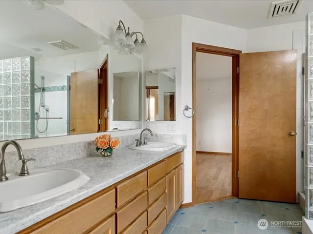 a bathroom with a double vanity sink and a mirror