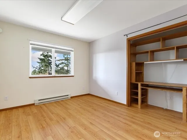 an empty room with wooden floor and closet