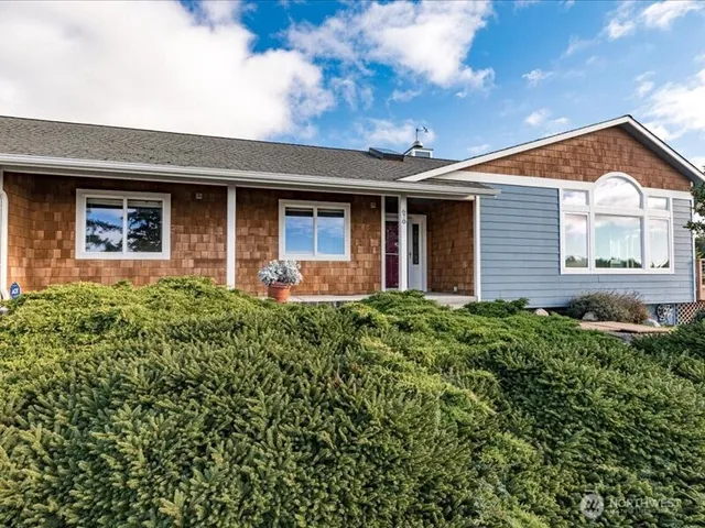 a view of a house with brick walls and a yard with plants