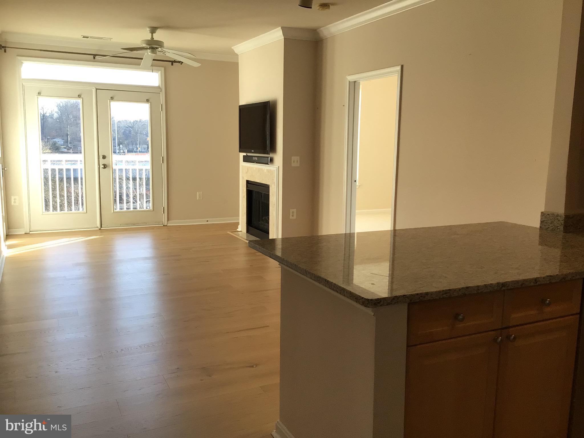 a view of a kitchen with wooden floor and a window