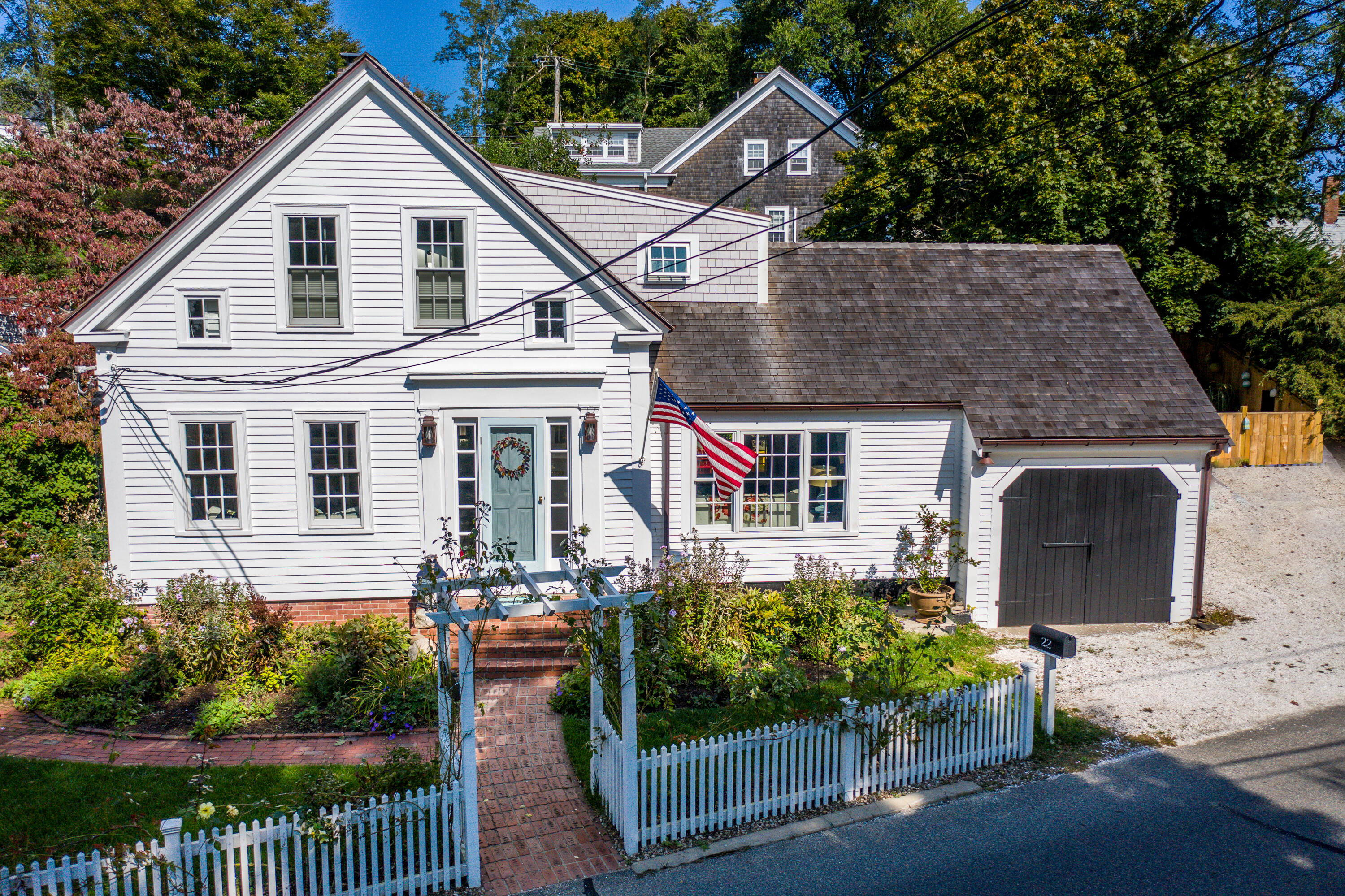 22 East Commercial Street Wellfleet, MA 02667 - Photo 1 of 68 a front view of a house with a garden and plants
