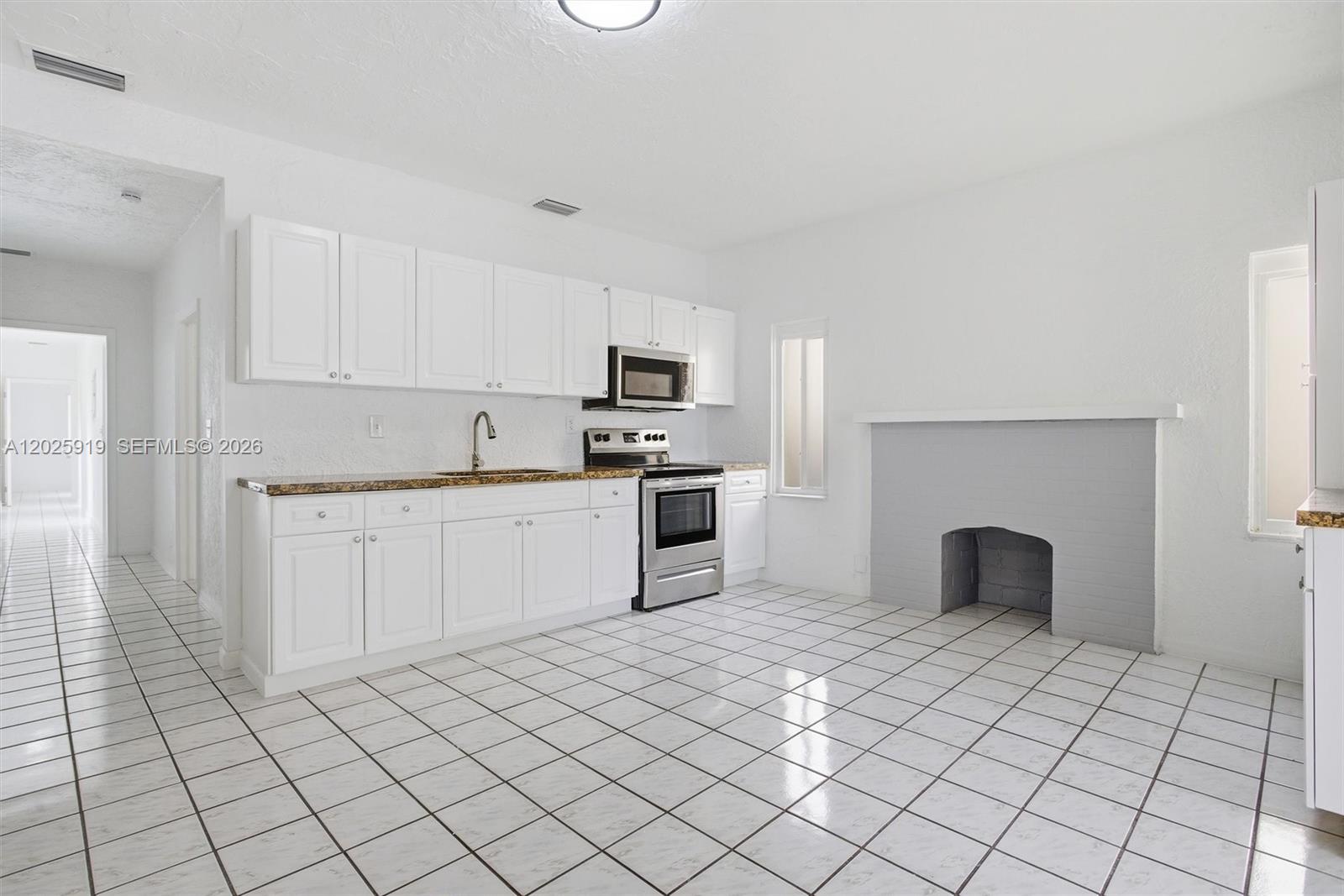 1743 Southwest 17th Street, Unit 1 Miami, FL 33145 - Photo 9 of 32 a kitchen with a sink a stove and cabinets