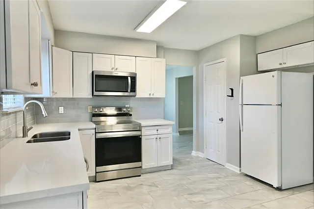 a kitchen with stainless steel appliances granite countertop a stove a refrigerator and a sink