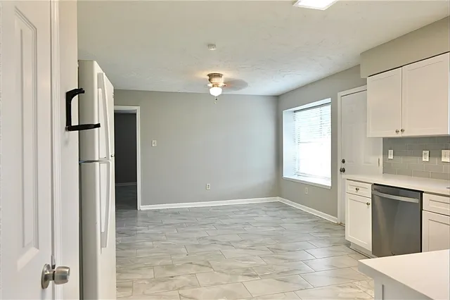 a view of a kitchen with granite countertop a refrigerator and a sink
