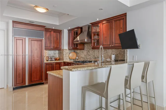 a kitchen with stainless steel appliances granite countertop a stove top oven a sink a dining table and chairs with wooden floor