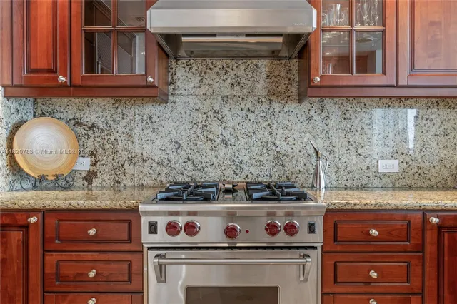 a kitchen with granite countertop a stove and a wooden cabinets