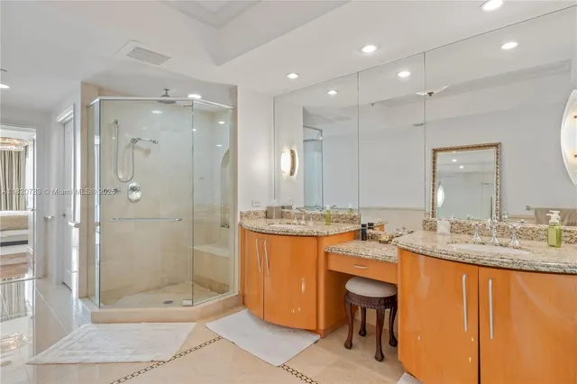 a bathroom with a granite countertop sink a toilet a mirror and shower