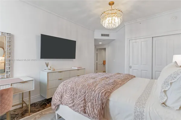 a bedroom with a bed and a flat screen tv